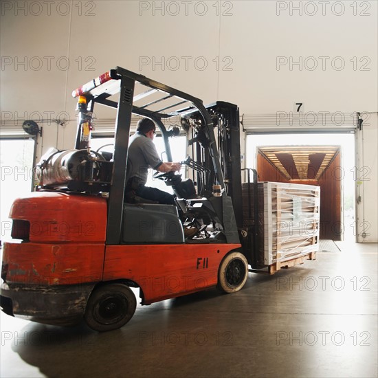 Forklift driver working in warehouse.