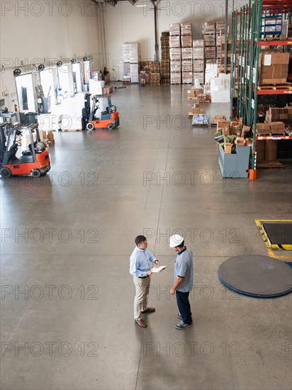 Workers talking in warehouse.