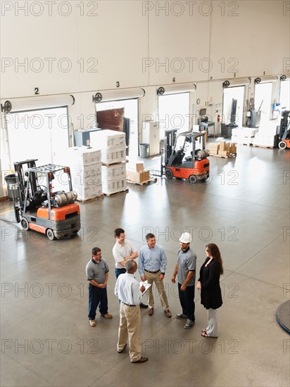 Workers talking in warehouse.