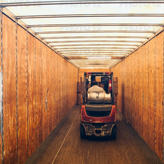 Forklift truck inside trailer.