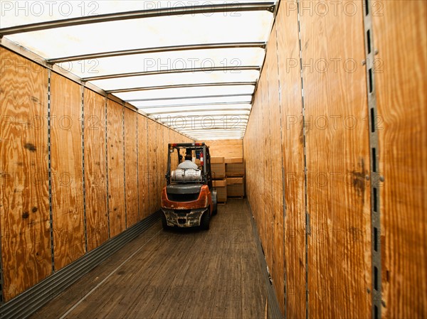 Forklift truck inside trailer.