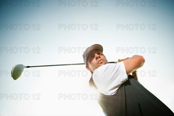 Low angle view of man playing golf.