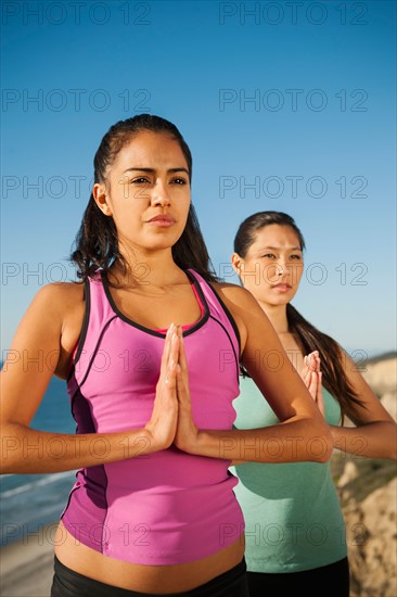 USA, California, San Diego, Two women practicing yoga on beach.