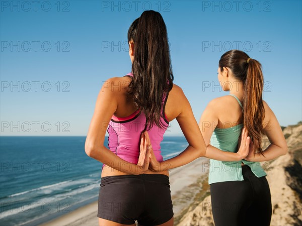 USA, California, San Diego, Two women practicing yoga on beach.