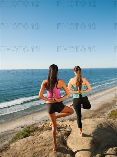 USA, California, San Diego, Two women practicing yoga on beach.