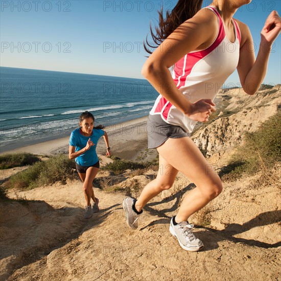 USA, California, San Diego, Two women jogging along sea coast.