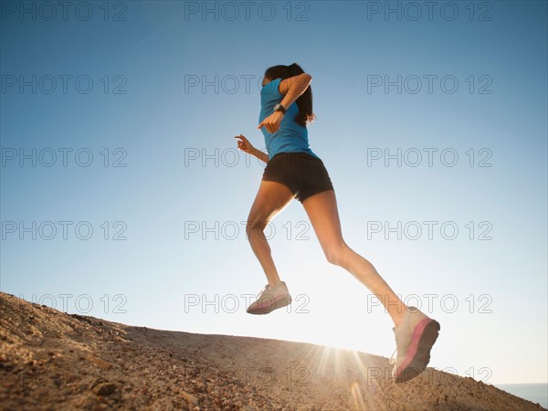 USA, California, San Diego, Woman jogging along sea coast.