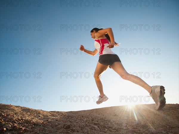 USA, California, San Diego, Woman jogging along sea coast.