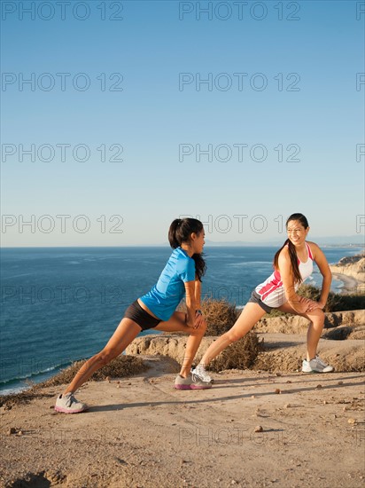 USA, California, San Diego, Two women stretching on beach.