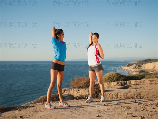 USA, California, San Diego, Two women stretching on beach.