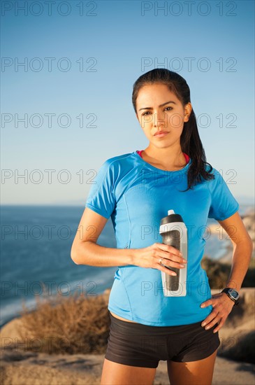 USA, California, San Diego, Portrait of female jogger holding water bottle.