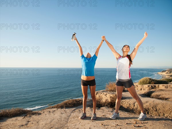 USA, California, San Diego, Two women stretching at sea coast.