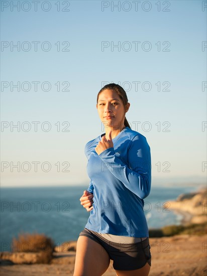 USA, California, San Diego, Woman jogging along sea coast.