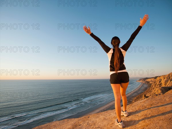 USA, California, San Diego, Woman stretching at beach.