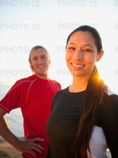 Portrait of male and female joggers at sea.