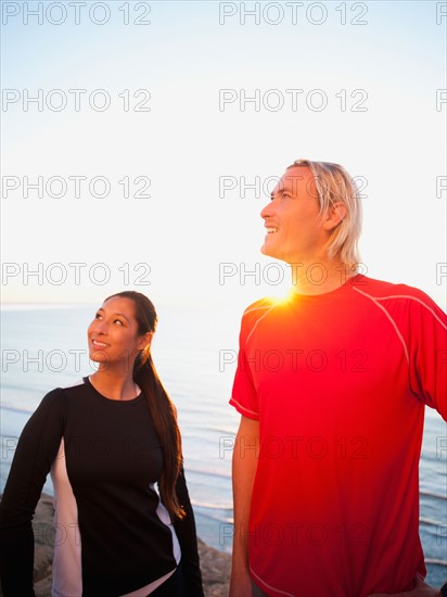 Portrait of male and female joggers at sea.