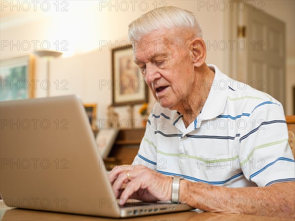 Senior man using laptop.