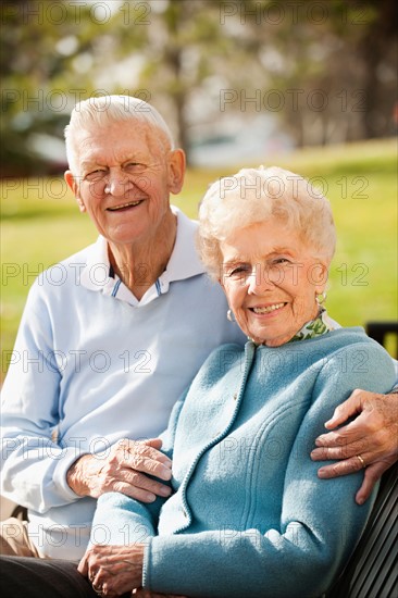 Portrait of senior couple on park bench.