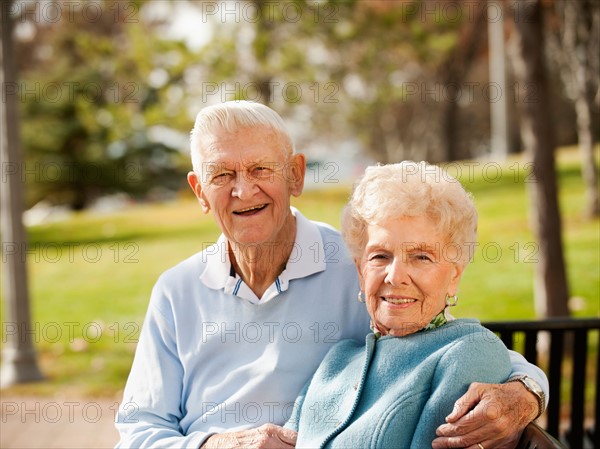 Portrait of senior couple on park bench.