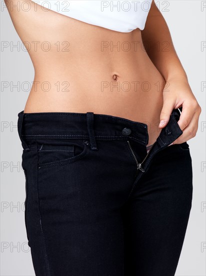Midsection of slim young woman with flat belly. Photo : Yuri Arcurs