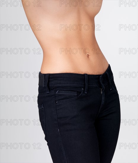 Midsection of slim young woman with flat belly. Photo : Yuri Arcurs