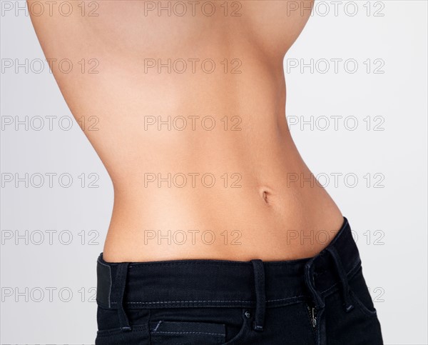 Midsection of slim young woman with flat belly. Photo : Yuri Arcurs