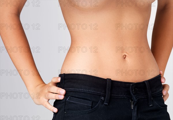 Midsection of slim young woman with flat belly. Photo : Yuri Arcurs