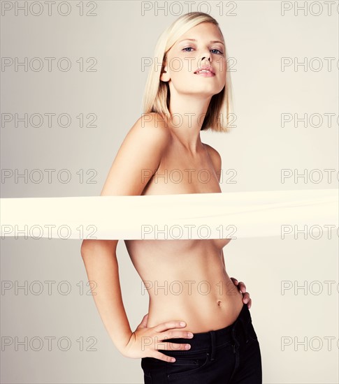 Studio portrait of young shirtless woman. Photo : Yuri Arcurs