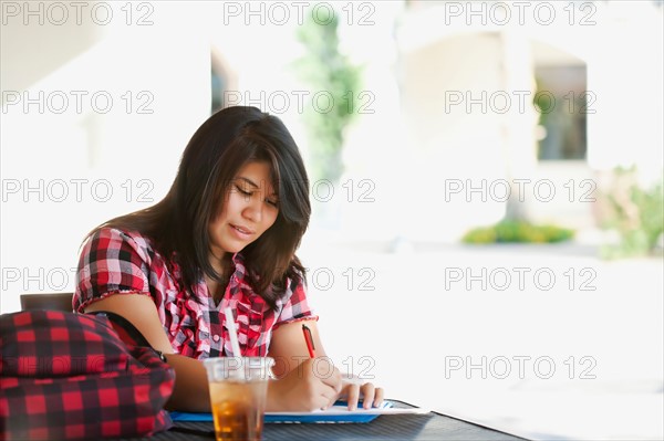 Young woman studying in outdoor cafe. Photo : Sarah M. Golonka