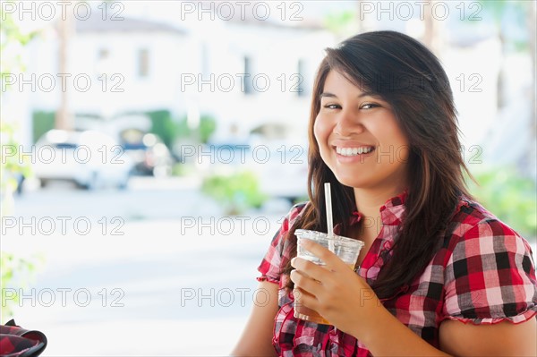 USA, California, La Quinta, Portrait of young woman drinking tea in outdoor cafe. Photo : Sarah M. Golonka