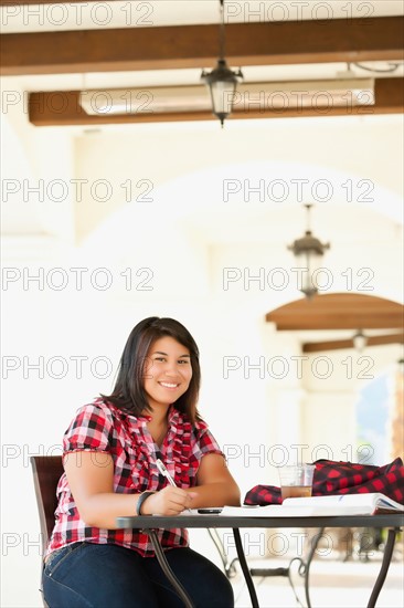 Young woman studying in outdoor cafe. Photo : Sarah M. Golonka