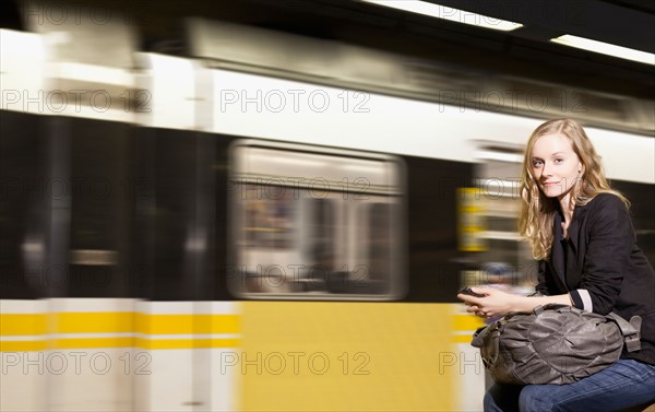 USA, California, Los Angeles, Woman sending text messages on subway station. Photo : Sarah M. Golonka