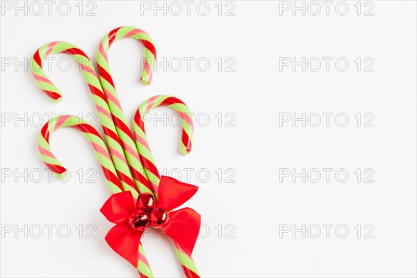 Striped candy canes with red ribbon, studio shot. Photo : Sarah M. Golonka