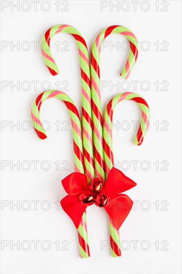 Striped candy canes with red ribbon, studio shot. Photo : Sarah M. Golonka