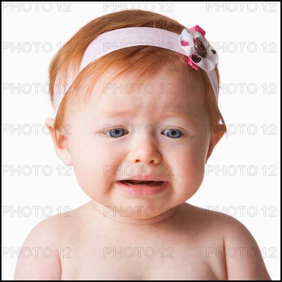 Portrait of baby girl (6-11 months) crying, studio shot. Photo : Mike Kemp