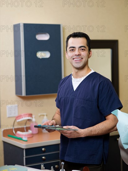 Portrait of smiling dentist in surgery. Photo : Dan Bannister