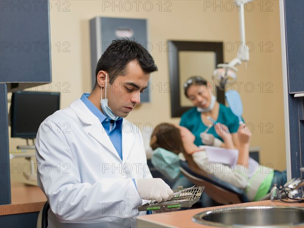 Dentists and patient in dental surgery. Photo : Dan Bannister