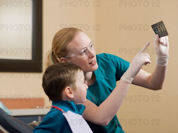 Dentists showing x-ray image to patient. Photo : Dan Bannister