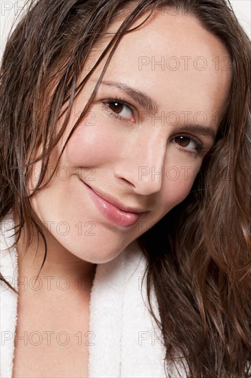 Portrait of smiling woman with wet hair, studio shot. Photo : Jan Scherders