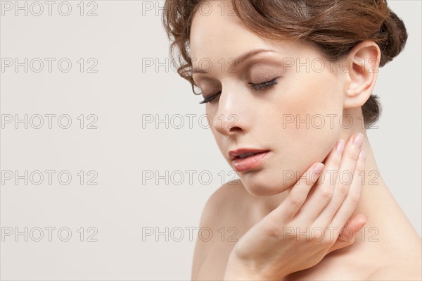 Portrait of beautiful young woman with eyes closed, studio shot. Photo : Jan Scherders