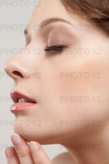 Profile of beautiful young woman with eyes closed, studio shot. Photo : Jan Scherders