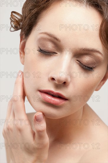 Portrait of beautiful young woman with eyes closed, studio shot. Photo : Jan Scherders