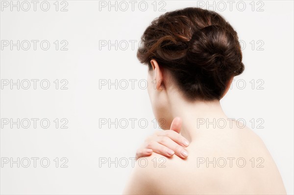 Rear view of beautiful young woman, studio shot. Photo : Jan Scherders