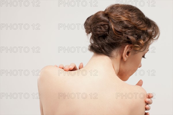 Rear view of beautiful young woman, studio shot. Photo : Jan Scherders