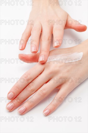 Close up of woman's hands applying moisturizer, studio shot. Photo : Jan Scherders