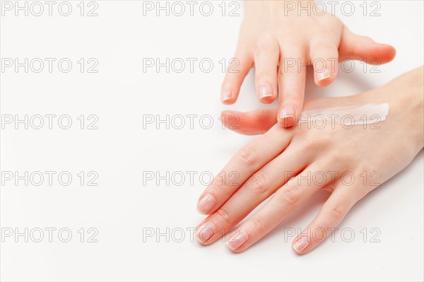 Close up of woman's hands applying moisturizer, studio shot. Photo : Jan Scherders