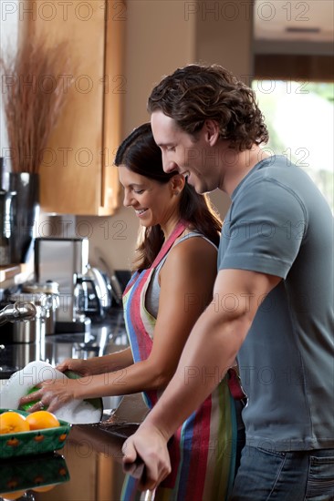 Couple washing dishes. Photo : db2stock