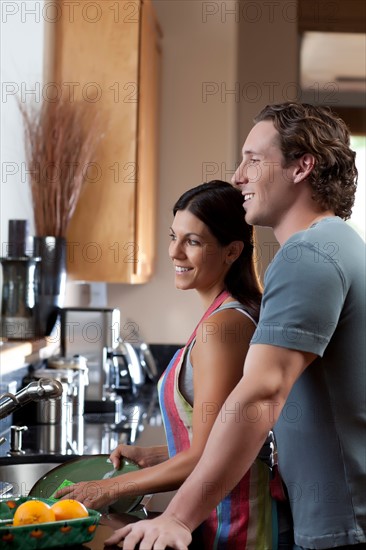 Couple washing dishes. Photo : db2stock