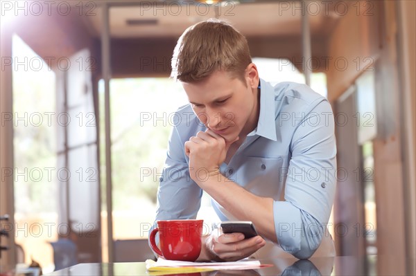 Man texting at home. Photo : db2stock