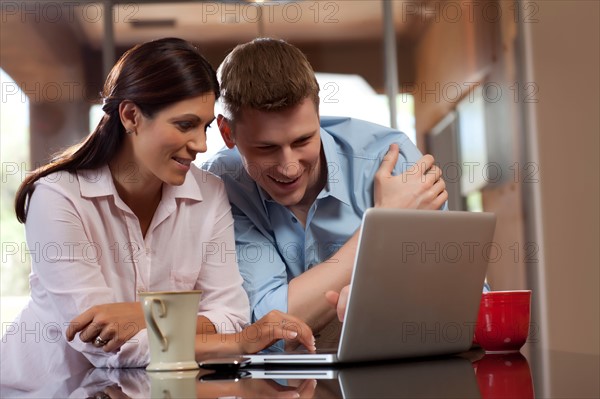 Couple looking at laptop. Photo : db2stock